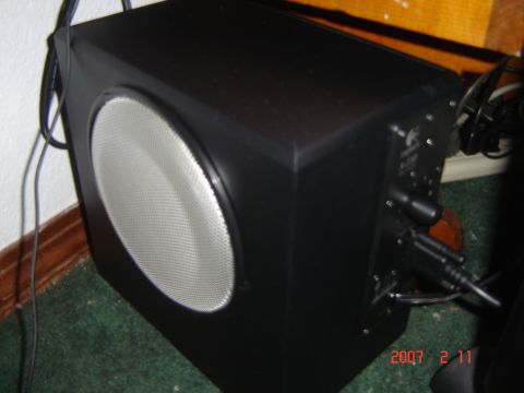 1993 Ford Bronco - Subwoofer speaker with visible connections on the rear panel and mesh grille on the front.