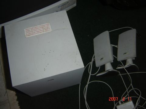 1993 Ford Bronco - A white subwoofer and two satellite speakers are shown on a dark carpeted surface.