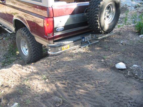 1996 Ford Bronco - The rear of a maroon Ford Bronco is visible, with a spare tire mounted on the back and a Texas license plate.