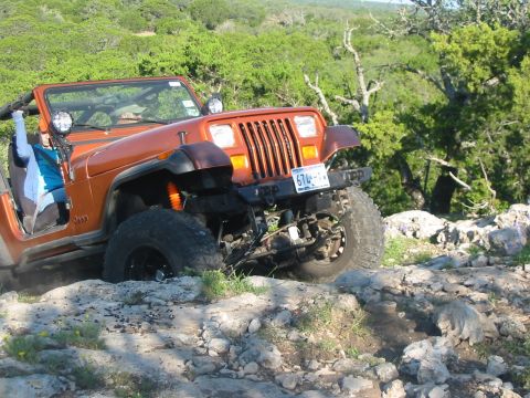 1996 Ford Bronco - A Jeep Wrangler navigates a rocky trail, its off-road capabilities.