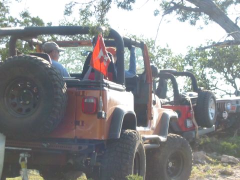 1996 Ford Bronco - Multiple Jeeps are seen on an off-road trail, with one orange Jeep in the foreground.