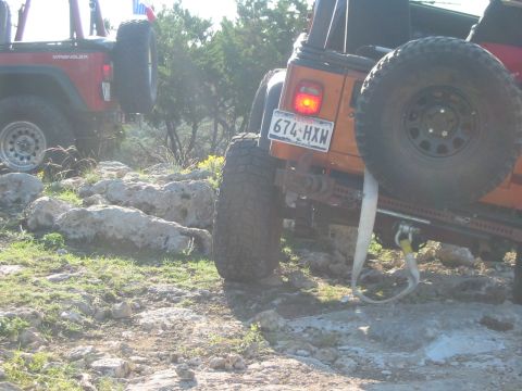 1996 Ford Bronco - Two Jeep Wranglers navigate a rocky trail under a bright sky.