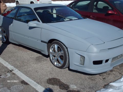 1995 Ford Probe - A 1995 Ford Probe, prepped for paint, sits in a parking lot next to another vehicle.