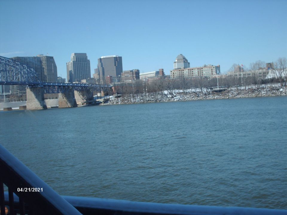 City skyline across a river with a bridge and snow on the banks