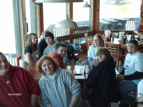 1995 Ford Probe - A group of young adults are seated around tables in a restaurant, enjoying each other's company.