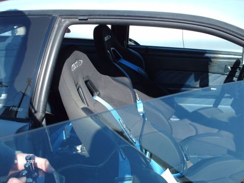 1995 Ford Probe - The interior of the car features racing seats with blue harnesses and visible text on the seats.