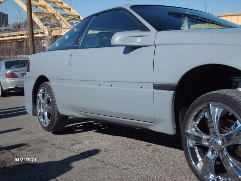 1995 Ford Probe - A gray coupe with custom chrome wheels is parked outdoors, with another car visible in the background.