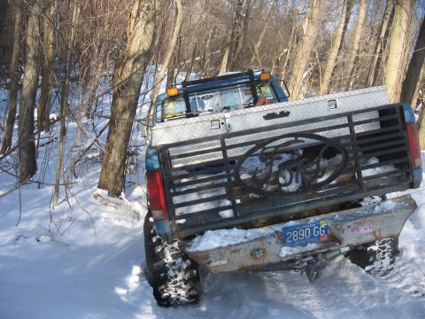 1979 Ford Bronco - Ford pickup truck with custom tailgate and toolbox driving in snow. License plate 2890 GG.