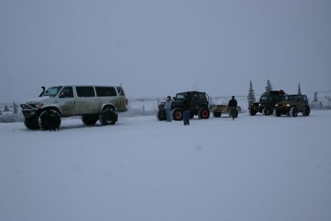 2003 Jeep TJ - Modified off-road vehicles are gathered in a snowy, open area with trees in the background.
