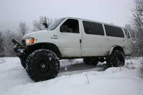 2003 Jeep TJ - This modified van is equipped with massive tires and a snorkel, ready for snowy terrain.