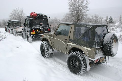 2003 Jeep TJ - Several off-road vehicles navigate a snow-covered path during a winter excursion.