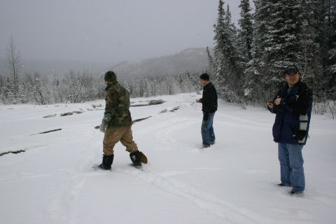 2003 Jeep TJ - Three men are in a snowy environment with trees and hills in the distance.