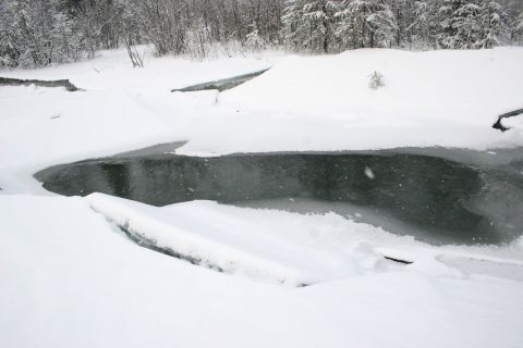 2003 Jeep TJ - A winter scene shows a partially frozen river surrounded by snow-covered trees and banks.