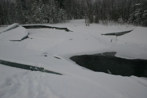 2003 Jeep TJ - Winter scene with fractured ice on a dark, frozen surface surrounded by snow.