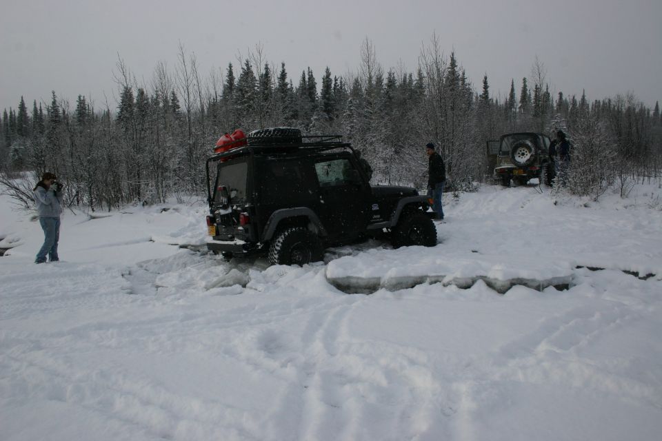 Black 2003 Jeep TJ stuck in snow with another Jeep in background