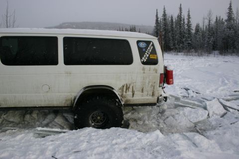 2003 Jeep TJ - A white van is stuck in a patch of broken ice and snow, with trees in the background.