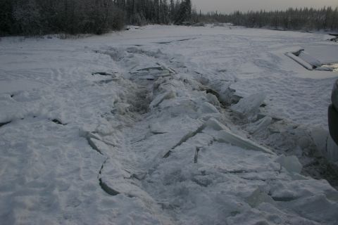 2003 Jeep TJ - A vehicle navigates a treacherous path of broken ice and snow, with trees in the background.