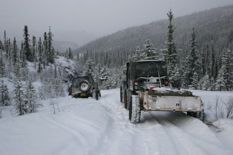 2003 Jeep TJ - Two Jeeps navigate a snow-covered trail in a wooded, mountainous area.