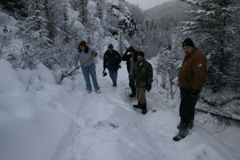 2003 Jeep TJ - People navigate a snowy path through a wooded mountain landscape in winter.