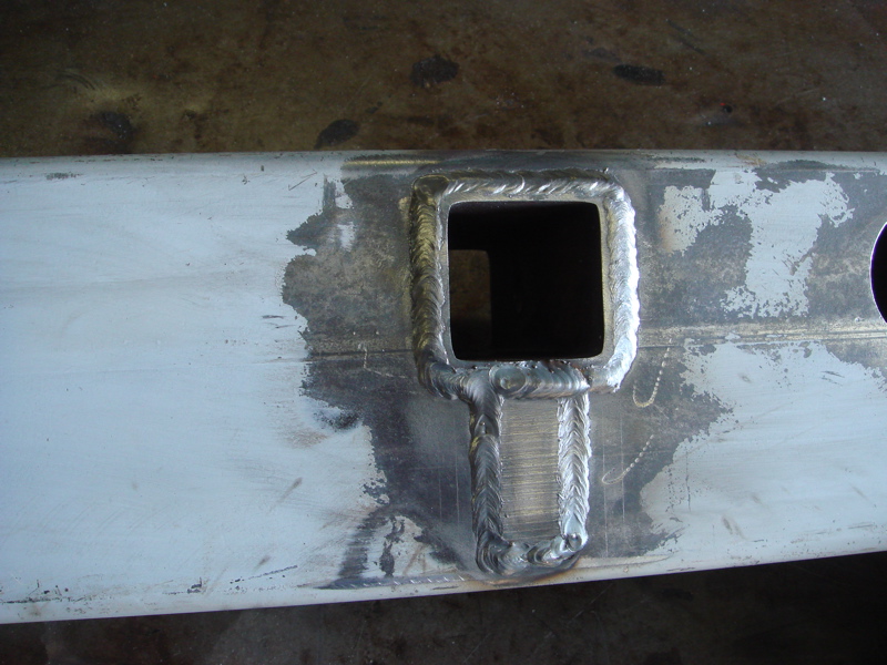 Close-up of a square hole welded onto a metal bar, likely part of a custom bumper