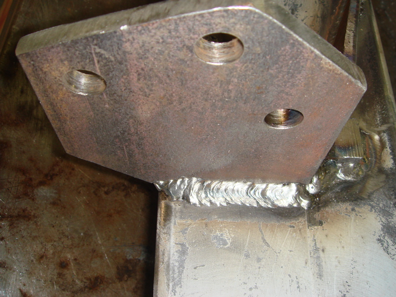 Metal bracket with three bolt holes welded to a steel beam