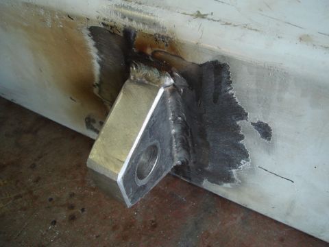 1996 Ford Bronco - Close-up of a metal bracket welded onto a beam, with visible signs of welding and heat discoloration.
