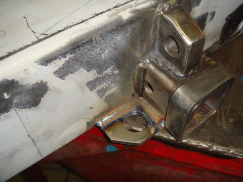 1996 Ford Bronco - Close-up of a welded metal bracket with mounting holes on a vehicle frame.