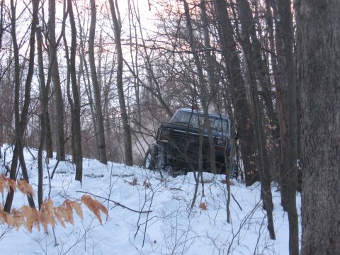 1979 Ford Bronco - A 1979 Ford Bronco tackles a snowy incline in a wooded area.