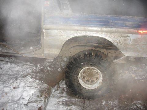 1979 Ford Bronco - A muddy truck sits in a snowy, wooded area, viewed from the side.