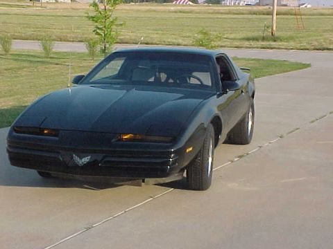 1989 Pontiac Firebird - A black 1985 Pontiac Firebird coupe is shown from the front-left quarter angle on a paved surface.