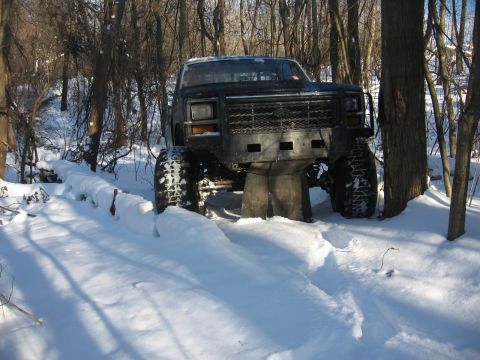 1979 Ford Bronco - This heavily modified truck appears to be stuck in deep snow, with its large tires barely visible.