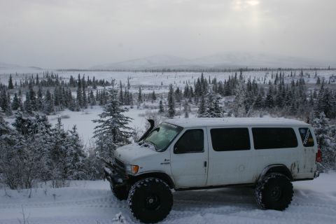 2003 Jeep TJ - A white van equipped for off-road conditions sits in a snow-covered forest.