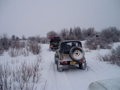 2000 Ford E350 - Two Jeeps navigate a snow-covered path through a winter landscape.