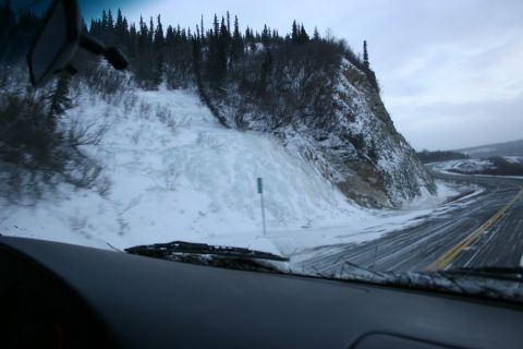 2003 Jeep TJ - View from inside a vehicle on a snowy road next to a cliff with ice formations.