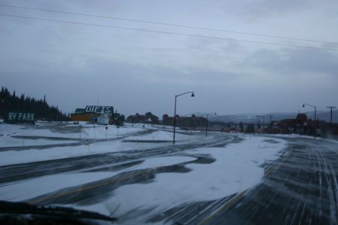 2003 Jeep TJ - Winter scene on a road with signs for RV Park and Gifts, buildings visible.