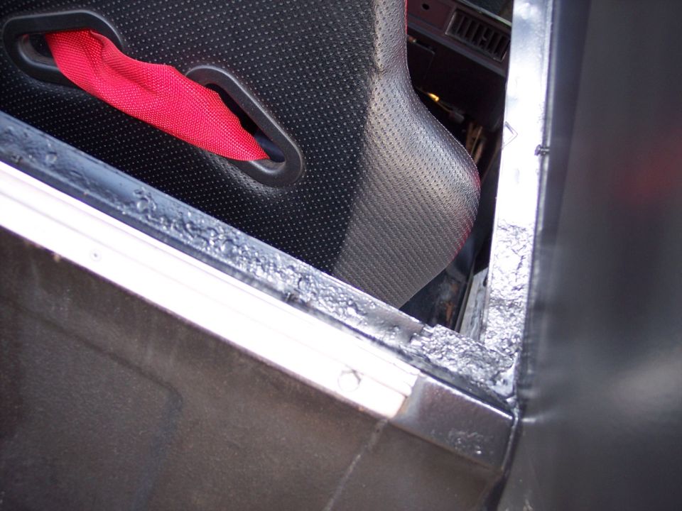 Bare welded door beltline and window channel with black door panel and red strap