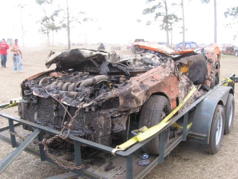 1974 Ford F-100 - This heavily damaged vehicle appears to have been involved in a fire and is being transported on a trailer.
