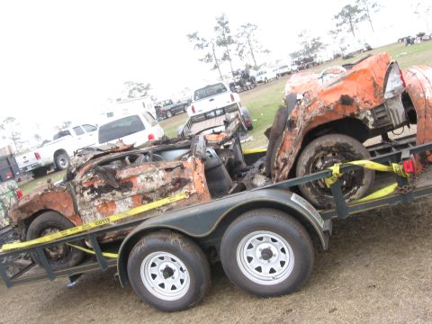1974 Ford F-100 - A severely damaged vehicle is transported on a trailer, with other vehicles visible in the background.