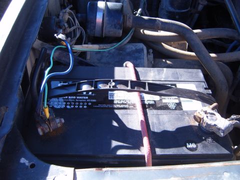 1988 Ford Bronco - Close-up view of a car battery and associated engine bay components.