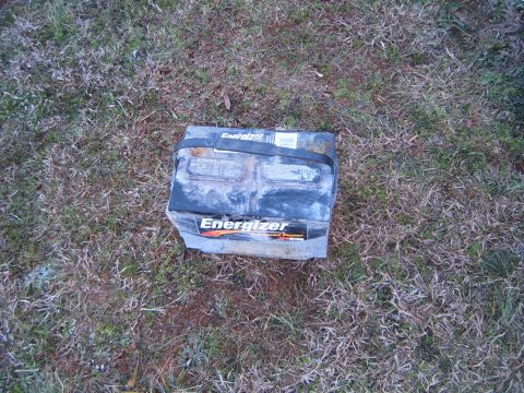 1988 Ford Bronco - An old Energizer car battery rests on the grass.