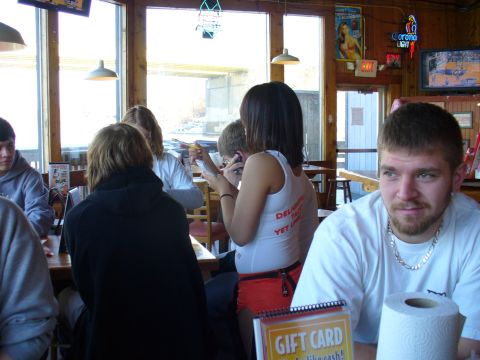 1991 Ford Probe - Interior view of a restaurant with patrons seated at tables and a man in the foreground.