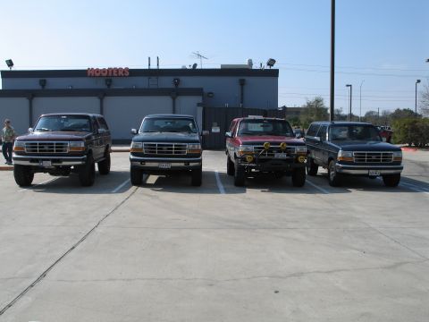 1995 Ford Bronco - Four Ford Broncos are parked in a lot in front of a Hooters restaurant.