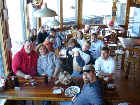 1991 Ford Probe - A group of people are seated at tables in a casual dining establishment, enjoying each other's company.