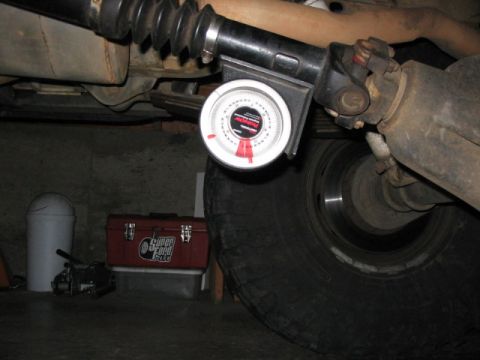 1995 Ford Bronco - Driveshaft angle gauge mounted on vehicle undercarriage near a large tire.