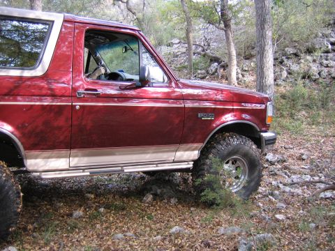1996 Ford Bronco - This 1996 Ford Bronco is shown in a wooded area, its distinctive body style and off-road tires.