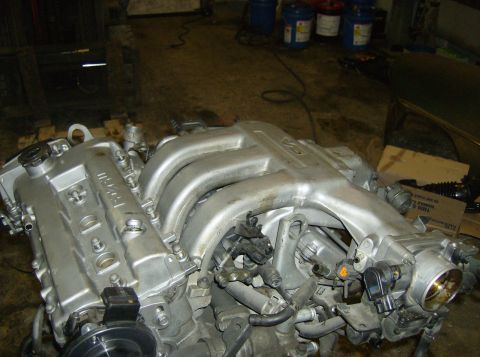 1996 Ford Probe - A close-up view of a Mazda KL-DE V6 engine, likely removed from a vehicle for repair or replacement.