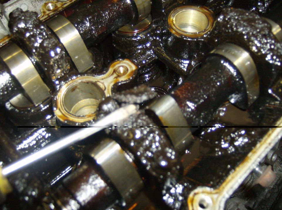engine's camshafts covered in thick, black sludge