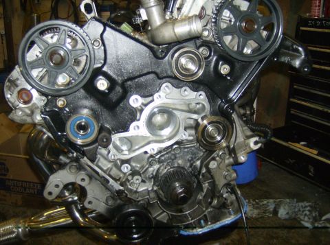 1996 Ford Probe - Close-up view of an engine's timing belt system, showing various pulleys and the water pump assembly.