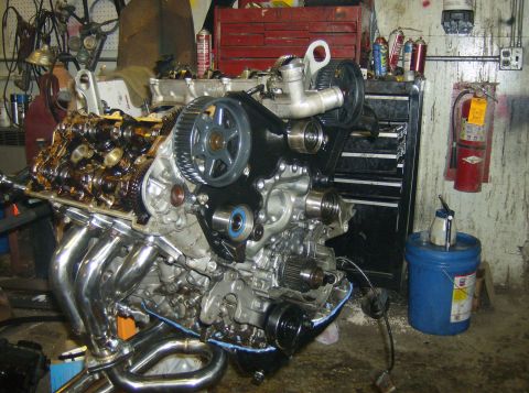 1996 Ford Probe - Engine assembly with chrome exhaust headers and timing belt components is shown in a workshop.
