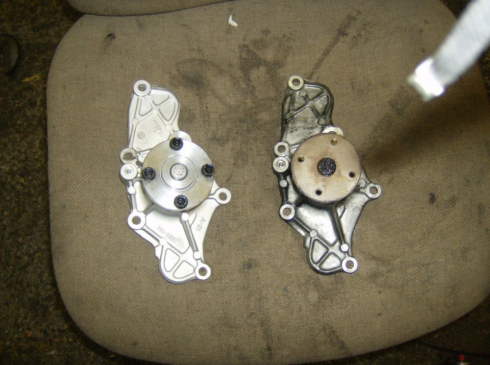 New and old car water pumps side-by-side on a fabric surface